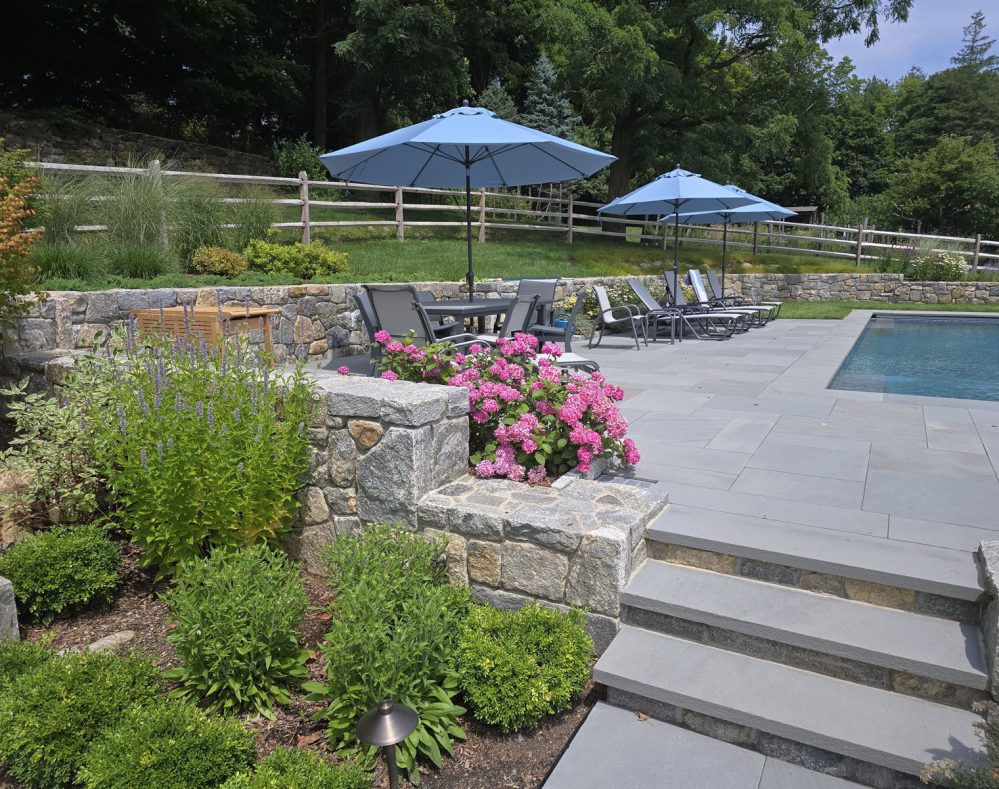 Steps up to pool with lounge chairs and umbrellas